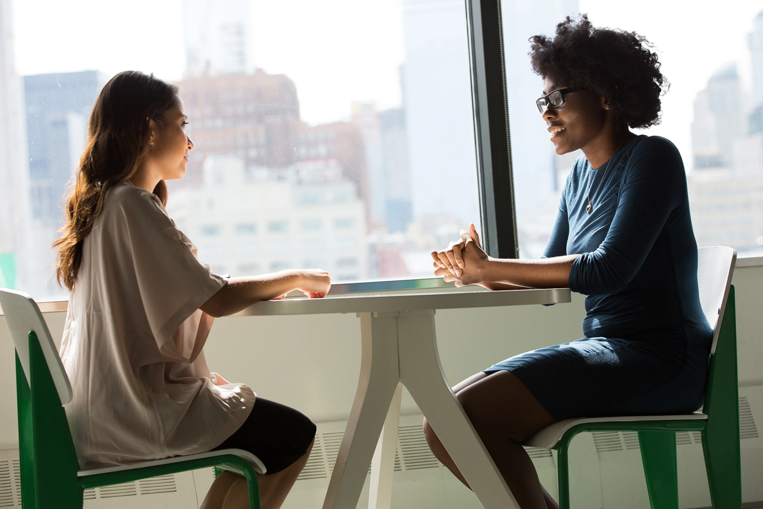 two people sitting down across from each other at a small table